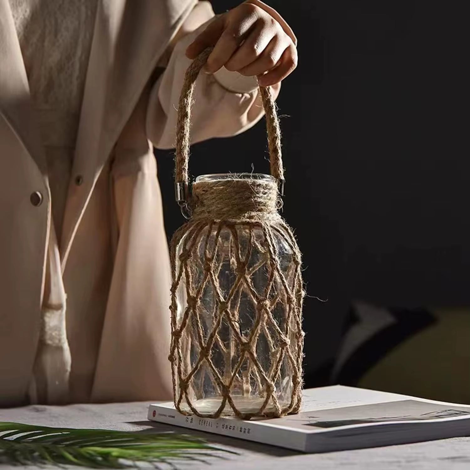 A hand‑woven hemp rope glass vase — a clear glass vessel wrapped in natural hemp fiber. Perfect for dried flowers, it adds texture and warm, rustic charm. Ideal for boho, Nordic, or minimalist interiors.