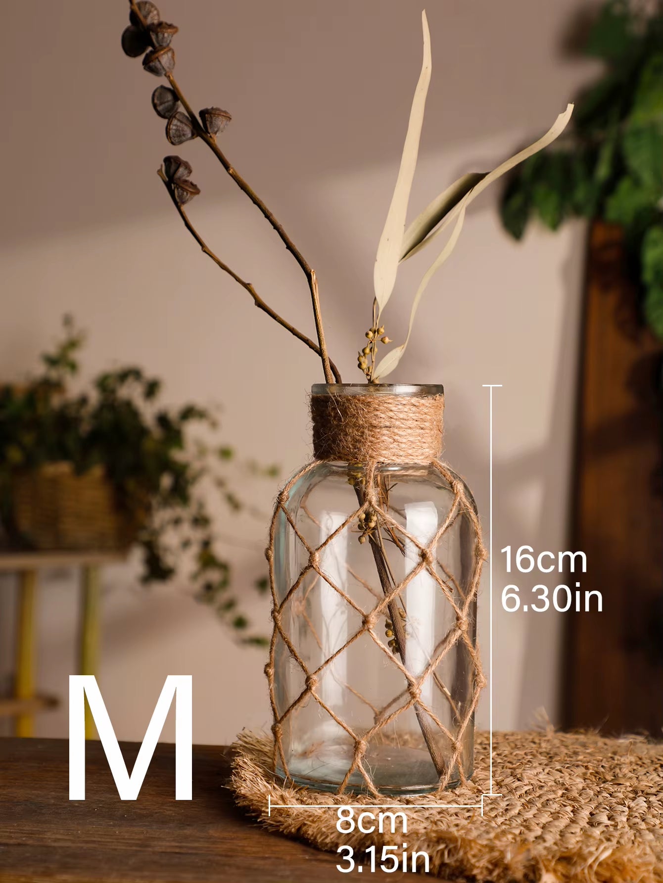 A hand‑woven hemp rope glass vase — a clear glass vessel wrapped in natural hemp fiber. Perfect for dried flowers, it adds texture and warm, rustic charm. Ideal for boho, Nordic, or minimalist interiors.