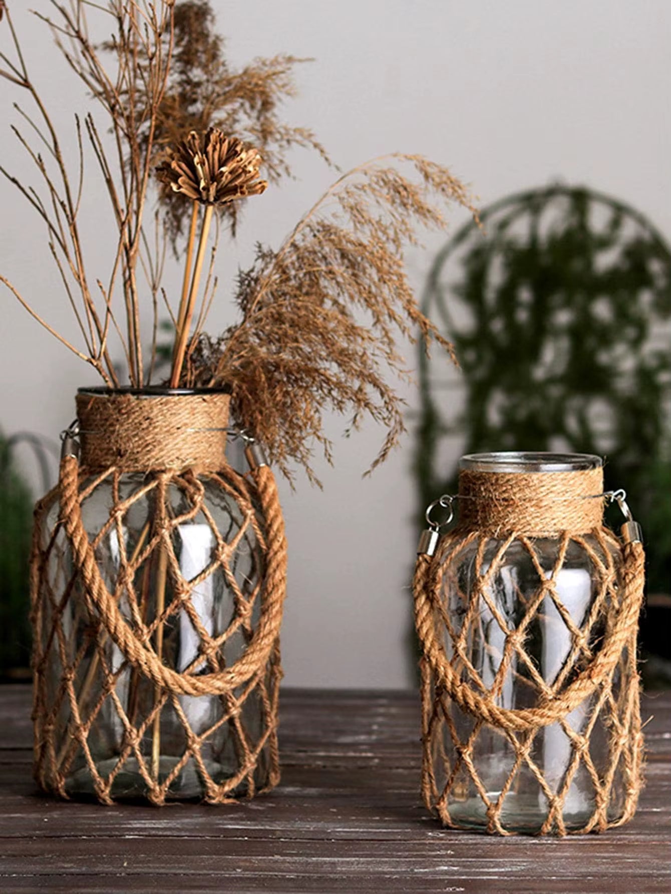 A hand‑woven hemp rope glass vase — a clear glass vessel wrapped in natural hemp fiber. Perfect for dried flowers, it adds texture and warm, rustic charm. Ideal for boho, Nordic, or minimalist interiors.