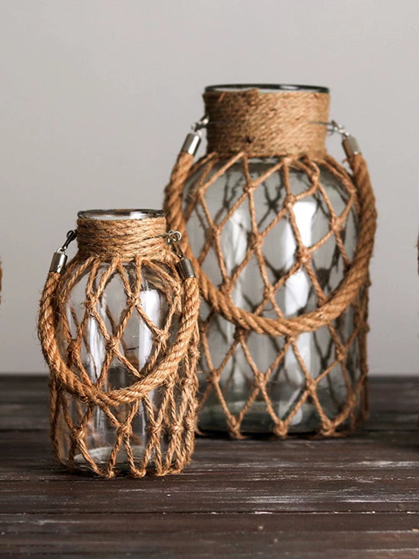 A hand‑woven hemp rope glass vase — a clear glass vessel wrapped in natural hemp fiber. Perfect for dried flowers, it adds texture and warm, rustic charm. Ideal for boho, Nordic, or minimalist interiors.